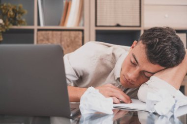 İş adamı başını katlanmış ellerin üzerine koyup iş yerinde uyudu. Aşırı yüklü ofis çalışanı rutin monoton evrak işlerinden yoruldu. Motivasyonsuz işçi, uykusuzluk ve kronik yorgunluk sendromu konsepti 
