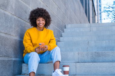 Şehrin sokaklarında milenyum melez kızı. Pozitif genç Afro-Amerikan kadın web sörfü, bilgi arama, açık havada online alışveriş 