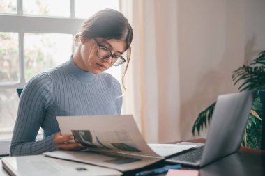 Evde ders çalışan ve ödevlerini yapan genç ve güzel bir kadın. İnternette bilgisayar ya da dizüstü bilgisayar kullanan genç bir kız.. 