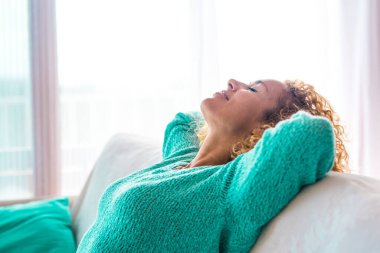 Kapatın ve genç, kıvırcık bir kadının portresini çekin. Evdeki kanepede ya da kanepede dinlenen ve uyuyan. Tatiller ve boş zaman yaşam tarzı. 