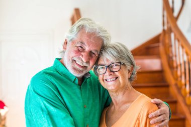 İki mutlu yaşlının portresi ve kapanışı ya da olgun ve yaşlı insanların gülümsemesi ve kameraya bakması - evde eğlenen emekliler. 