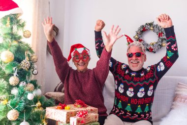 Kalın elbiseli son sınıf çifti ve Noel Baba şapkası ile evde süslenmiş Noel ağacının önünde dans edip kutlama yapıyorlar. Yaşlı ve romantik heteroseksüel çift Noel festivalini birlikte kutluyor. 