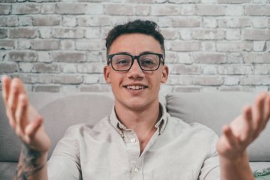 Konferansta kameraya konuşan genç bir öğrencinin portresi. Kolunda dövme olan bir adam iş için iletişim kuran kameraya bakıyor.. 