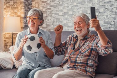 Mutlu son sınıflar ya da futbol taraftarları televizyonda maç izleyip zaferi evde kutluyorlar. Aile, spor ve eğlence konsepti. 