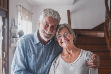 İki mutlu ve sağlıklı yaşlı insanın portresi. Gülümseyen ve kameraya bakan yaşlı insanlar. Evde eğlenen ve eğlenen olgun büyükanne ve büyükbabalara yakın durun.. 