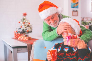 Kalın elbiseli son sınıf çifti ve Noel Baba şapkalı, yaşlı karısının gözlerini kapatan adam ona sürpriz bir hediye getirmiş. Yaşlı ve romantik heteroseksüel çift Noel festivalini birlikte kutluyor. 