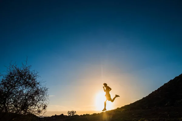 stock image one teenager running and jogging alone in the mountains at the sunset on the rocks - healthy and fitness lifestyle concept - man workout 