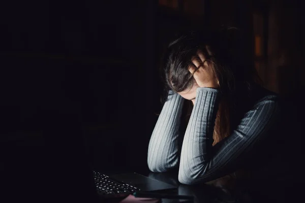 一位悲伤疲惫的年轻女士在家里工作时 双手捂住脸 感觉很糟 女孩精疲力竭 晚上学习压力大 — 图库照片
