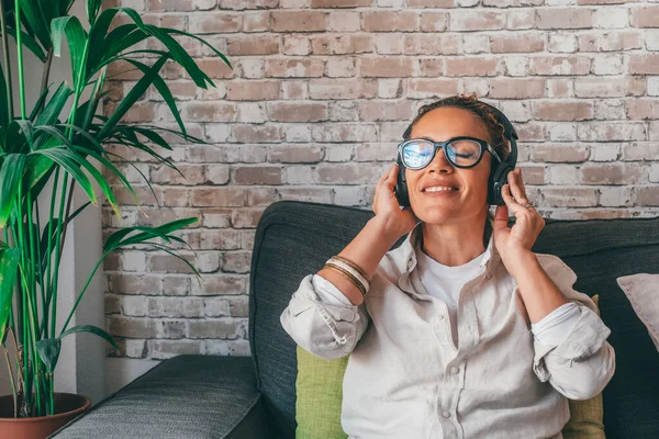 Χαμογελώντας Χιλιετή Καυκάσια Γυναίκα Απολαμβάνοντας Χρήση Ακουστικών Κάθεται Άνετο Καναπέ — Φωτογραφία Αρχείου