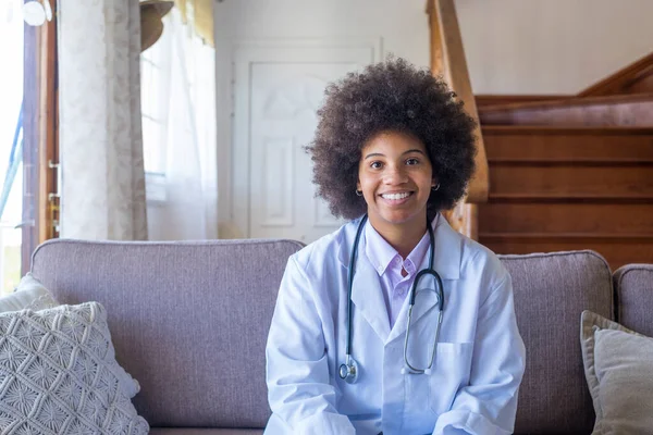 Smiling female physician, general practitioner consult patient online by video call. Portrait of happy african american woman doctor looking at camera. Healthcare worker consulting clinic patient online