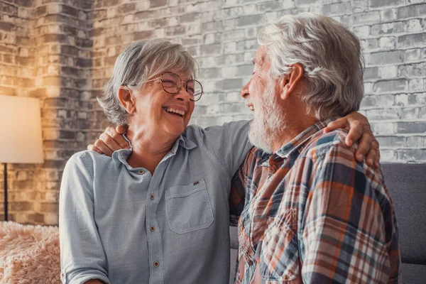 一对老夫妇在一起玩乐 在家里的沙发上享受 说话和笑的成熟人拥抱着 — 图库照片