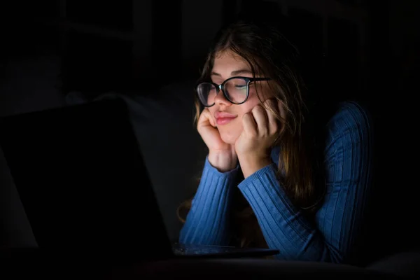 一个快乐且失眠的年轻女人深夜在客厅的沙发上用笔记本电脑聊天 网上女孩上网修订社交媒体 累了又累的女孩在工作时闭上眼睛 — 图库照片