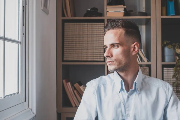 stock image Caucasian reflexive looking at laptop screen, reflecting on work, businessman independent working in a difficult project. Male person preparing at home in the office indoor. 