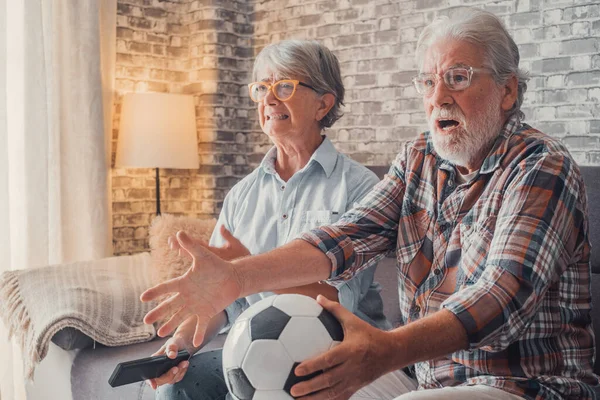 stock image Happy couple of seniors or football fans watching soccer on tv and frustrating and getting mad at home. Family, sports and entertainment concept. 