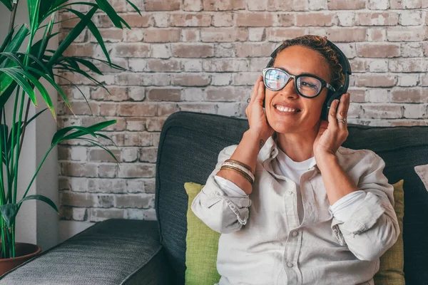 Χαμογελώντας Χιλιετή Καυκάσια Γυναίκα Απολαμβάνοντας Χρήση Ακουστικών Κάθεται Άνετο Καναπέ — Φωτογραφία Αρχείου
