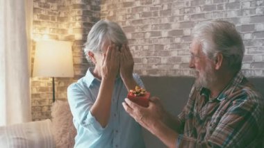 Olgun bir adam karısına yılbaşı ya da yıldönümü hediyesi veriyor. Şaşırmış emekli kadın kocasına sarılıyor..