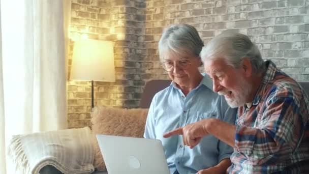 2人のかわいい高齢者のカップルは オンラインストアでインターネット上で購入し 彼らのパッケージを受け取るために屋外待って配達人を探します — ストック動画