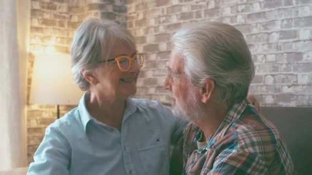 2人の高齢者のカップルは一緒に楽しさを持って抱擁し ソファの上で自宅でお互いを世話します 人生を楽しむ愛の成熟した人々 — ストック動画