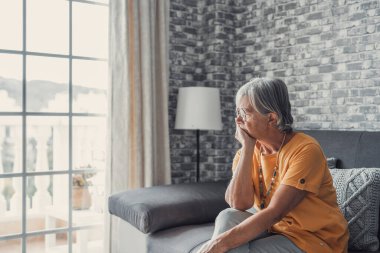 Face of senior caucasian hoary woman looking away deep in sad thoughts feels lonely close up portrait, recollect memories and life moments, depressed grandmother alone indoors, yearning for husband concept