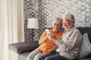 Yaşlı büyükbaba ve büyükanne akıllı telefon uygulamaları, orta yaşlı eş çevrimiçi eğlencelerden, eski koca, eski nesil ve modern teknoloji konseptiyle selfie çekmekten zevk alarak zaman geçiriyorlar.