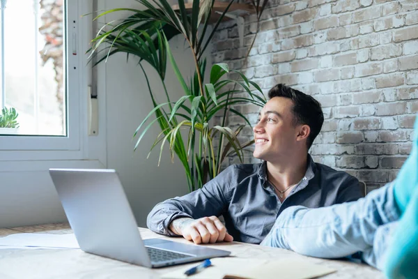 stock image Satisfied teenager happy to finish work with laptop at home, raises hands and puts feet up on table, relaxing after hard working day in expectation of weekend leave, relaxed workday, no stress