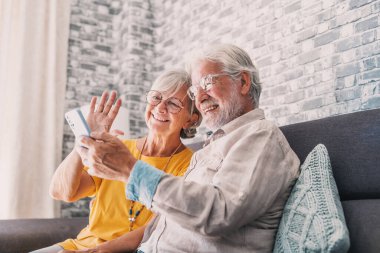Mutlu emekli aile çiftimiz cep telefonlarını video görüşmesi için kullanıyor, akrabalarla konuşuyor, iyi haberler alıyor, eğleniyor, gülümsüyor ve gülüyor. Tasasız, olgun emekliler hücrede sohbet ediyorlar.