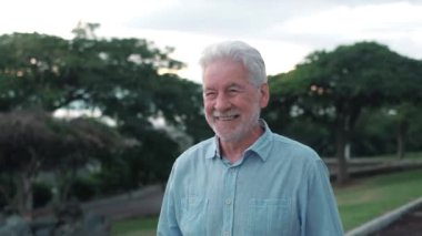 Gün batımında parkta kucaklaşan romantik yaşlı çiftin görüntüleri.