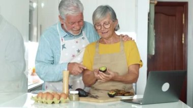 Güzel yaşlı çiftin mutfakta yemek pişirme görüntüleri.