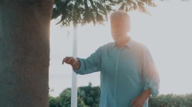 Yaşlı bir adamın kalp krizi geçirip parkta ağaca yaslandığı görüntüler.