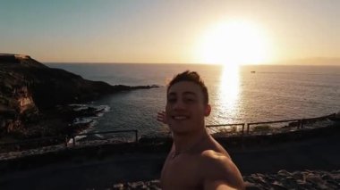 Yakışıklı delikanlının deniz kıyısında günbatımının keyfini çıkardığı görüntüler.