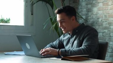 Konsantre olmuş yetenekli bin yıllık Kafkas işadamı bilgisayar kullanıyor, uzaktan iletişim kavramı kullanıyor..