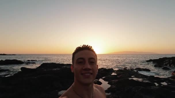 Zdjęcia Przystojnego Młodego Mężczyzny Cieszącego Się Zachodem Słońca Wybrzeżu — Wideo stockowe