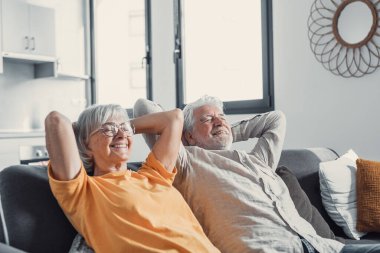 Huzurlu orta yaşlı erkek ve kadın kapalı gözleri evde rahat kanepede rahatlatıcı, olgun aile birlikte hayal, gri saçlı karısı ve koca başının arkasında elleri ile istirahat, nefes