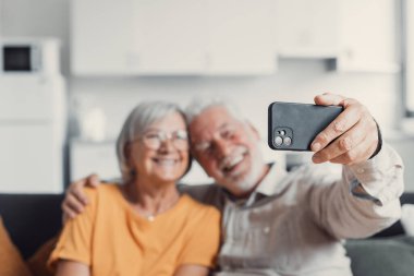 Mutlu yaşlı çift cep telefonu selfie alarak, gülümseyen üst düzey olgun eşleri orta yaşlı karısı ve emekli koca telefon tutarak gülüyor akıllı telefon kamera üzerinde otoportre yapmak, mobil ekran odaklanmak