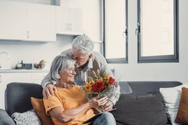 Yaşlı adam karısına çiçek veriyor. Sevgililer Günü için evdeki kanepede oturuyor. Emekliler birlikte sürprizin tadını çıkarıyorlar. Aşık insanlar eğleniyor.