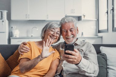 Mutlu emekli aile çiftimiz cep telefonlarını video görüşmesi için kullanıyor, akrabalarla konuşuyor, iyi haberler alıyor, eğleniyor, gülümsüyor ve gülüyor. Tasasız, olgun emekliler hücrede sohbet ediyorlar.