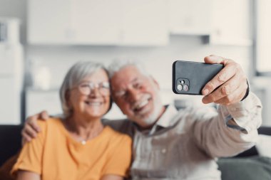 Mutlu yaşlı çift cep telefonu selfie alarak, gülümseyen üst düzey olgun eşleri orta yaşlı karısı ve emekli koca telefon tutarak gülüyor akıllı telefon kamera üzerinde otoportre yapmak, mobil ekran odaklanmak