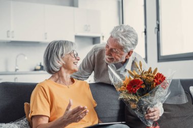 Yaşlı adam karısına çiçek veriyor. Sevgililer Günü için evdeki kanepede oturuyor. Emekliler birlikte sürprizin tadını çıkarıyorlar. Aşık insanlar eğleniyor.