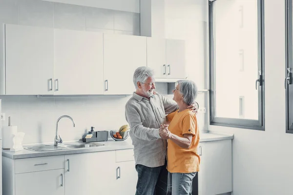 stock image Joyful active old retired romantic couple dancing laughing in living room, happy middle aged wife and elder husband having fun at home, smiling senior family grandparents relaxing bonding together