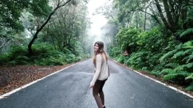 Ormanda yolda yürüyen genç ve güzel bir kadının görüntüleri.