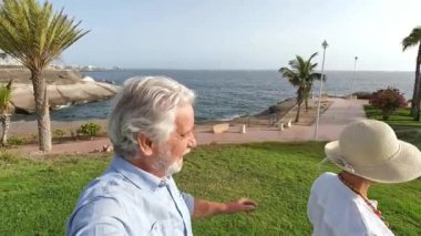 İki mutlu ve aktif yaşlının ya da emeklinin gün batımını seyrederken eğlenirken ve eğlenirken çekilmiş görüntüleri.