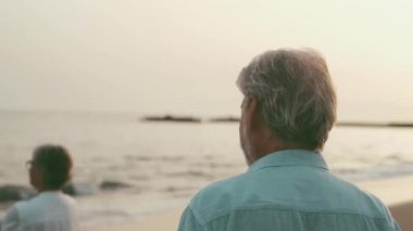 İki mutlu ve aktif yaşlının ya da emeklinin gün batımını seyrederken eğlenirken ve eğlenirken çekilmiş görüntüleri.
