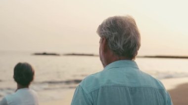İki mutlu ve aktif yaşlının ya da emeklinin gün batımını seyrederken eğlenirken ve eğlenirken çekilmiş görüntüleri.