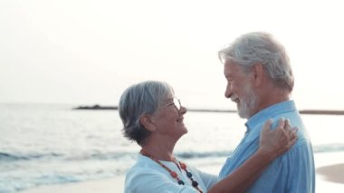 İki mutlu ve aktif yaşlının ya da emeklinin gün batımını seyrederken eğlenirken ve eğlenirken çekilmiş görüntüleri.