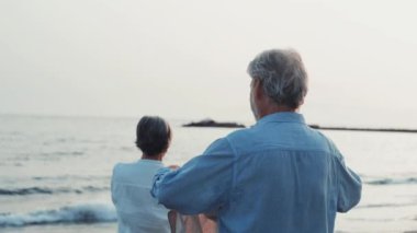 İki mutlu ve aktif yaşlının ya da emeklinin gün batımını seyrederken eğlenirken ve eğlenirken çekilmiş görüntüleri.