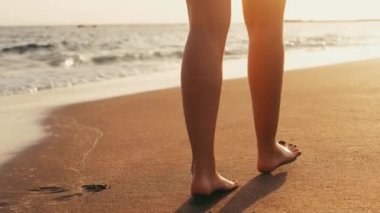 Gün batımında sahile vurmuş bir kadın görüntüsü.