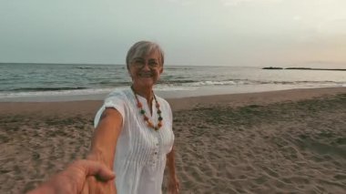 Sahilde kendilerini filme alan güzel, romantik yaşlı bir çiftin görüntüleri.