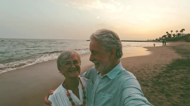 행복하고 활동적 노인이나 생활자 야외에서 휴가를 즐기며 바다에 노인들 석양을 — 비디오