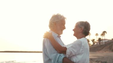 İki mutlu ve aktif yaşlının ya da emeklinin gün batımını seyrederken eğlenirken ve eğlenirken çekilmiş görüntüleri.