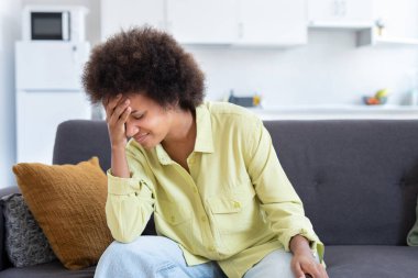 Üzgün stresli genç Afrikalı kadın masaj tapınaklar güçlü baş ağrısı kavramı hissediyorum, sinirli yorgun siyah kız ağrıyan kafa dokunarak evde kanepede oturan migren yüksek tansiyon muzdarip